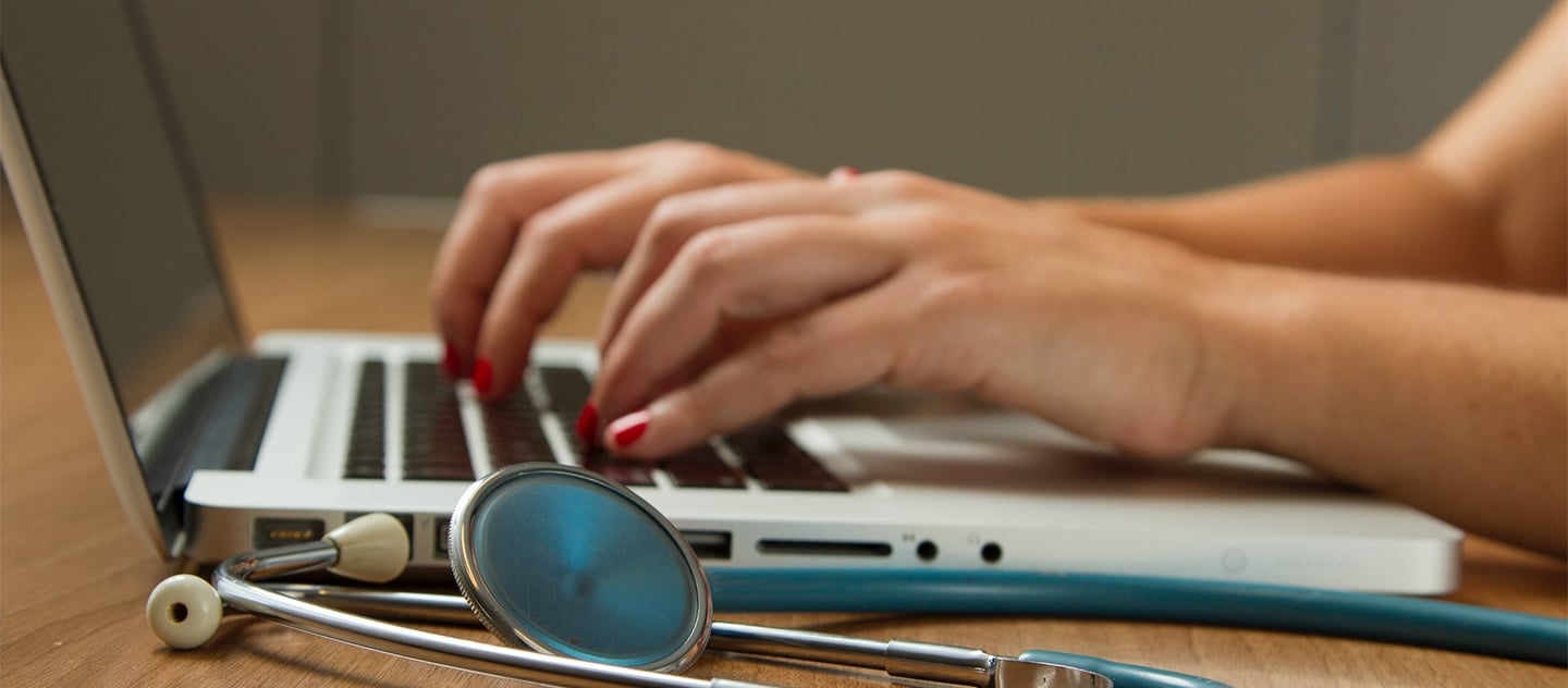 Hands typing on laptop.